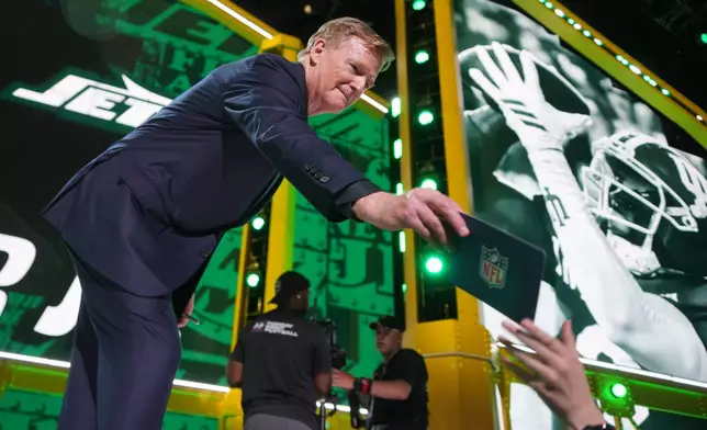 NFL Commissioner Roger Goodell hands out a card from the stage during the first round of the NFL football draft, Thursday, April 23, 2026, in Pittsburgh. (AP Photo/Gene J. Puskar)