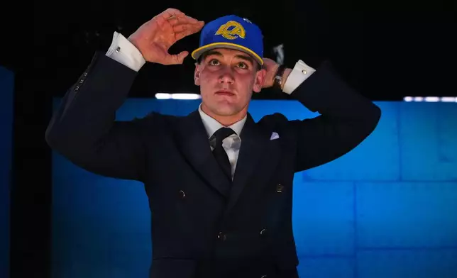 Alabama quarterback Ty Simpson puts on a hat after being chosen by the Los Angeles Rams with the 13th overall pick during the first round of the NFL football draft, Thursday, April 23, 2026, in Pittsburgh. (AP Photo/Jeff Roberson)
