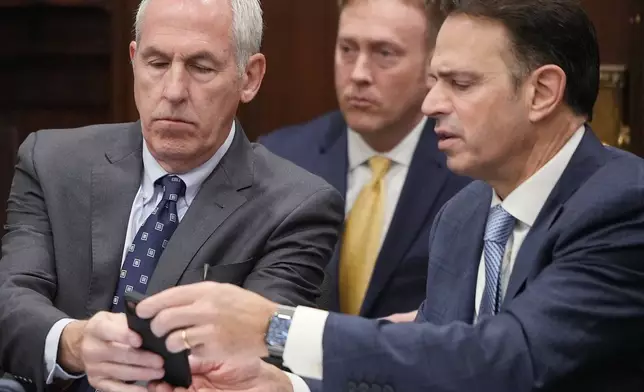 Defendants ex-FirstEnergy Senior Vice President Michael Dowling and defense attorney George Stamboulidis watches a live transcription of an in chamber conference on a jury question in Summit County Common Pleas Judge Susan Baker Ross' courtroom in Akron, Ohio, on Tuesday, March 31, 2026. (Mike Cardew /Akron Beacon Journal via AP, Pool)