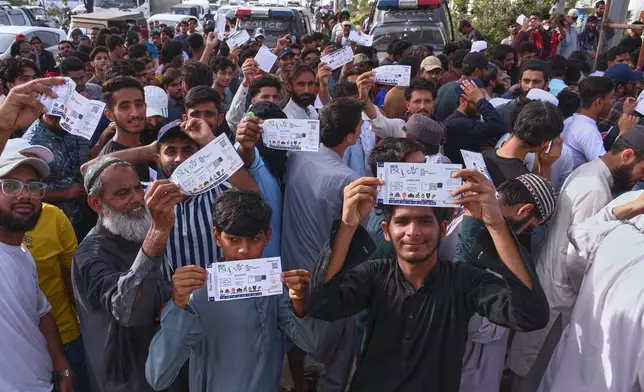 Fans show their tickets as they wait for the opening of the National Stadium for the Pakistan Super League Qualifier cricket match between Peshawar Zalmi and Islamabad United, in Karachi, Pakistan, Tuesday, April 28, 2026. (AP Photo/Ali Raza)