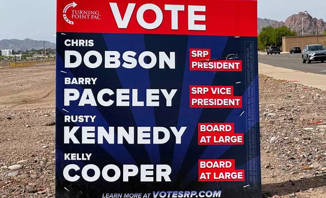 A sign supporting candidates for the Salt River Project board sits next to an intersection Monday, March 30, 2026 in Tempe, Ariz. (AP Photo/Jonathan J. Cooper)
