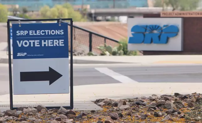 A sign directing voters sits outside the headquarters of Salt River Project on Monday, March 30, 2026, in Tempe, Ariz. (AP Photo/Jonathan J. Cooper)