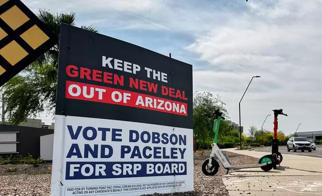 A sign supporting candidates for the Salt River Project board sits next to an intersection Monday, March 30, 2026 in Tempe, Ariz. (AP Photo/Jonathan J. Cooper)