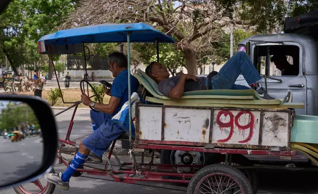 A man rests on mattresses atop a bicycle trailer in Havana, Wednesday, April 22, 2026. (AP Photo/Ramon Espinosa)
