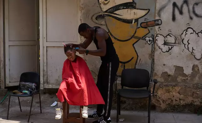 A barber cuts a boy's hair at his makeshift barbershop on the street in Havana, Wednesday, April 22, 2026. (AP Photo/Ramon Espinosa)