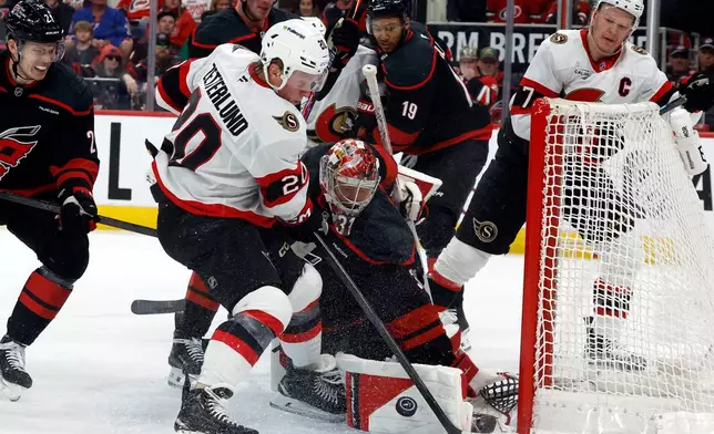 Carolina Hurricanes goaltender Frederik Andersen (31) blocks a shot by Ottawa Senators' Fabian Zetterlund (20) with Senators' Brady Tkachuk (7) looking on during the first period of Game 2 of an NHL hockey Stanley Cup first-round playoff series in Raleigh, N.C., Monday, April 20, 2026. (AP Photo/Karl DeBlaker)