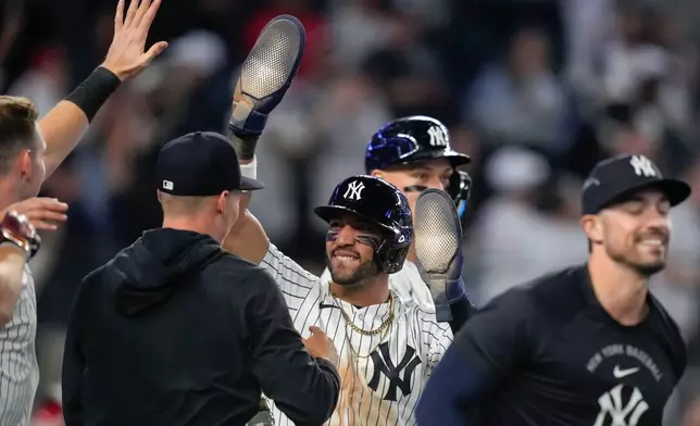 New York Yankees' José Caballero, center, celebrates with teammates after scoring during the ninth inning of a baseball game against the Los Angeles Angels, Monday, April 13, 2026, in New York. (AP Photo/Yuki Iwamura)