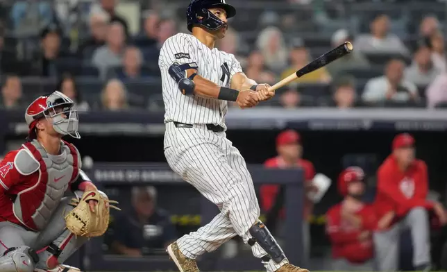 New York Yankees' Trent Grisham, right, watches his three-run home run during the fifth inning of a baseball game against the Los Angeles Angels, Monday, April 13, 2026, in New York. (AP Photo/Yuki Iwamura)