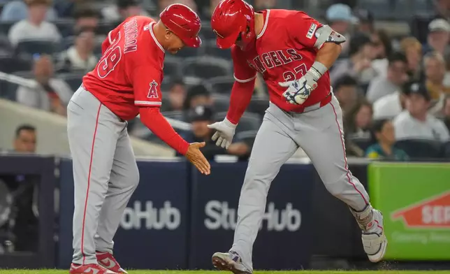 Los Angeles Angels' Mike Trout, right, celebrates with Angels third base coach Keith Johnson, left, after hitting a three-run home run during the sixth inning of a baseball game against the New York Yankees, Monday, April 13, 2026, in New York. (AP Photo/Yuki Iwamura)