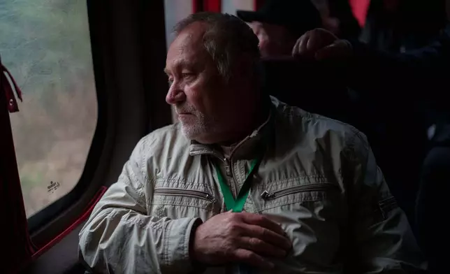 A worker who was sent to clean up the effects of the 1986 Chernobyl nuclear power plant accident, rides in a bus during a visit to the facility, Tuesday, April 21, 2026, in Chernobyl Ukraine. (AP Photo/Evgeniy Maloletka)