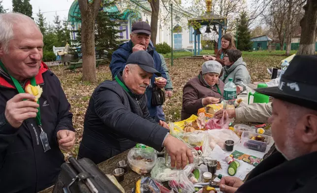 Volodymyr Vechirko, 62, one of the workers sent to clean up contamination from the Chernobyl nuclear power plant, pours vodka during lunch near the plant, Tuesday, April 21, 2026. In Chernobyl, Ukraine. (AP Photo/Evgeniy Maloletka)