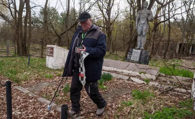A man measures radiation near the site of the Chernobyl nuclear power plant, Tuesday, April 21, 2026, in Chernobyl, Ukraine. (AP Photo/Evgeniy Maloletka)