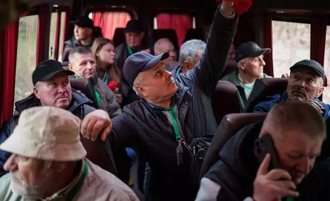Volodymyr Vechirko, 62, one of the workers who helped decontaminate the area around the Chernobyl nuclear power plant after the 1986 accident, rides in a bus with fellow workers for a visit to the region ahead of the 40th anniversary of the disaster in Chernobyl, Ukraine, Tuesday, April 21, 2026. (AP Photo/Evgeniy Maloletka)