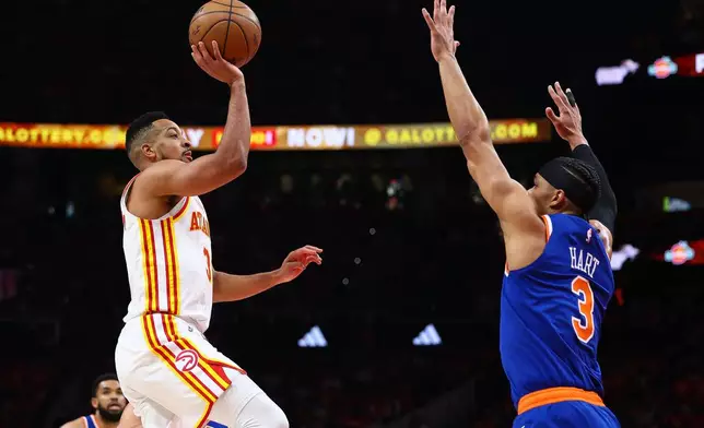 Atlanta Hawks guard CJ McCollum, left, shoots against New York Knicks guard Josh Hart, right, during the first half in Game 3 of a first-round NBA playoffs basketball series, Thursday, April 23, 2026, in Atlanta. (AP Photo/Colin Hubbard)