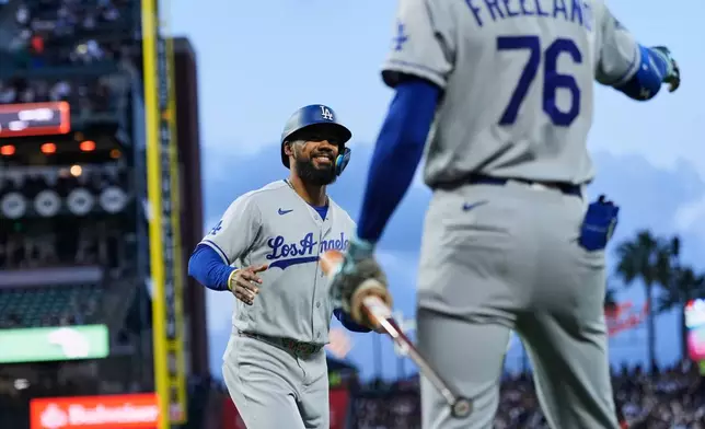 Los Angeles Dodgers' Teoscar Hernández, left, celebrates with Alex Freeland after scoring against the San Francisco Giants during the fourth inning of a baseball game Tuesday, April 21, 2026, in San Francisco. (AP Photo/Godofredo A. Vásquez)