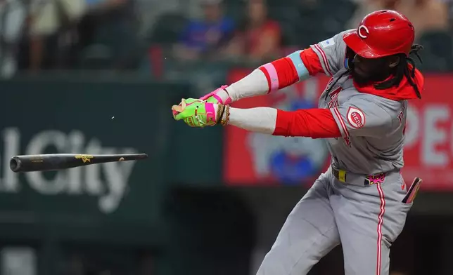 Cincinnati Reds' Elly de la Cruz breaks his bat while hitting a single, scoring teammate Matt McLain, during the first inning of a baseball game against the Texas Rangers, Saturday, April 4, 2026, in Arlington, Texas. (AP Photo/LM Otero)