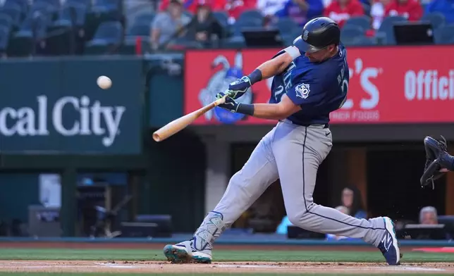 Seattle Mariners' Cal Raleigh connects on a solo home run off Texas Rangers starting pitcher Jacob deGrom during the first inning of a baseball game Monday, April 6, 2026, in Arlington, Texas. (AP Photo/Julio Cortez)