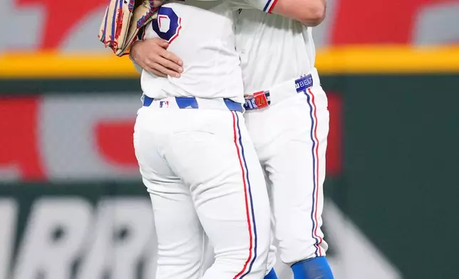 Texas Rangers outfielders Wyatt Langford, left, and Brandon Nimmo react after their team defeated the Seattle Mariners 2-1 during a baseball game Monday, April 6, 2026, in Arlington, Texas. (AP Photo/Julio Cortez)