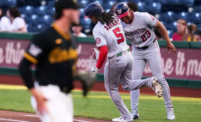 Washington Nationals' CJ Abrams (5) is greeted by first base coach Corey Ray (23) as he rounds first after hitting a solo home run off Pittsburgh Pirates pitcher Paul Skenes, left, during the first inning of a baseball game in Pittsburgh, Monday, April 13, 2026. (AP Photo/Gene J. Puskar)