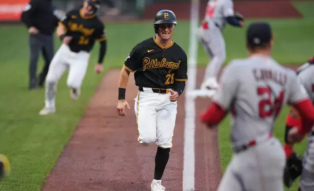 Pittsburgh Pirates' Jake Mangum (28) and Henry Davis, left rear, score on a single by Brandon Lowe off Washington Nationals pitcher Cade Cavalli (24) during the second inning of a baseball game in Pittsburgh, Monday, April 13, 2026. (AP Photo/Gene J. Puskar)