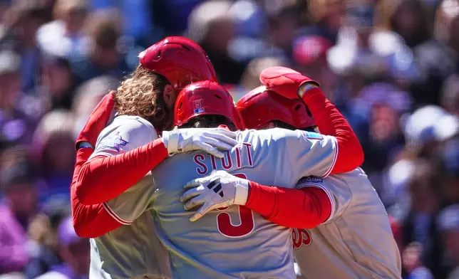 From left to right, Philadelphia Phillies' Alec Bohm, Bryson Stott and Brandon Marsh celebrate as Marsh crosses home plate after hitting a three-run home run off Colorado Rockies starting pitcher Michael Lorenzen in the first inning of a baseball game Friday, April 3, 2026, in Denver. (AP Photo/David Zalubowski)