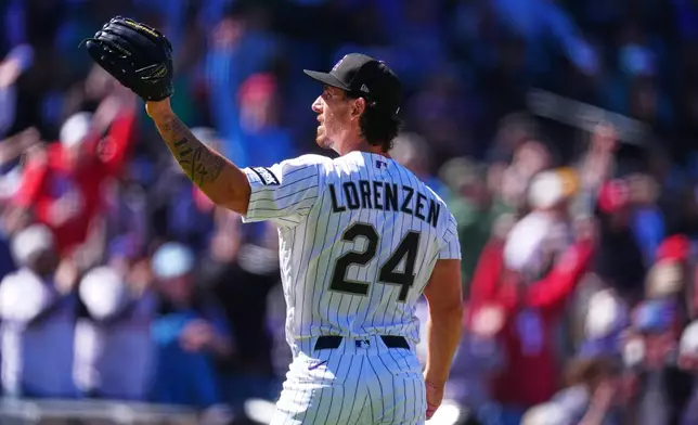 Colorado Rockies starting pitcher Michael Lorenzen calls for a new ball after giving up a three-run home run to Philadelphia Phillies' Brandon Marsh in the first inning of a baseball game Friday, April 3, 2026, in Denver. (AP Photo/David Zalubowski)