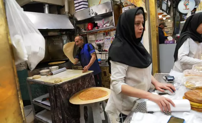 Employees work inside a bakery near Tajrish Bazaar in Tehran, Iran, Tuesday, April 7, 2026. (AP Photo/Francisco Seco)