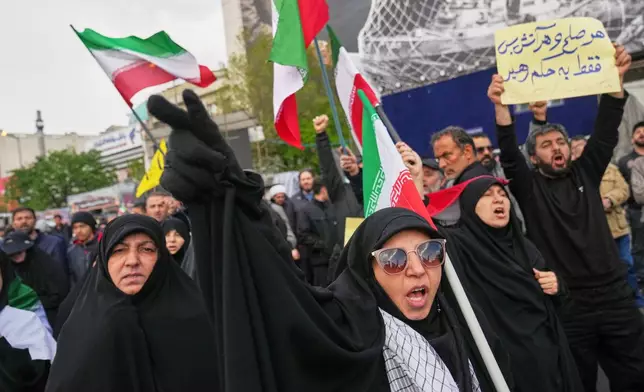 Government supporters chant slogans after the announcement of a two-week ceasefire with the United States and Israel in Tehran, Iran, Wednesday, April 8, 2026. (AP Photo/Francisco Seco)