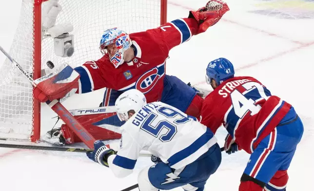 Tampa Bay Lightning's Jake Guentzel (59) scores against Montreal Canadiens goaltender Jakub Dobes (75) as Canadiens' Jayden Struble (47) defends during the second period of Game 4 in a first-round NHL hockey Stanley Cup playoff series in Montreal, Sunday, April 26, 2026. (Christinne Muschi/The Canadian Press via AP)
