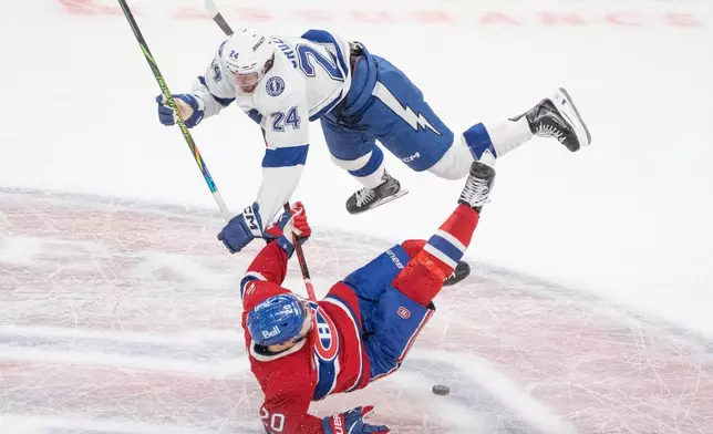 Tampa Bay Lightning's Max Crozier (24) checks Montreal Canadiens' Juraj Slafkovsky (20) during the second period of Game 4 in a first-round NHL hockey Stanley Cup playoff series in Montreal, Sunday, April 26, 2026. (Christinne Muschi/The Canadian Press via AP)