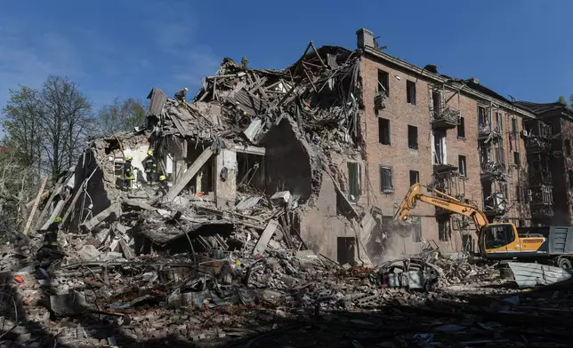 Rescue workers clear the rubble of a residential building destroyed by a Russian strike, in Dnipro, Ukraine, Saturday, April 25, 2026. (AP Photo/Mykola Synelnykov)