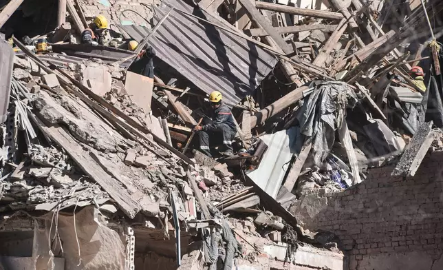 Rescue workers clear the rubble of a residential building destroyed by a Russian strike, in Dnipro, Ukraine, Saturday, April 25, 2026. (AP Photo/Mykola Synelnykov)