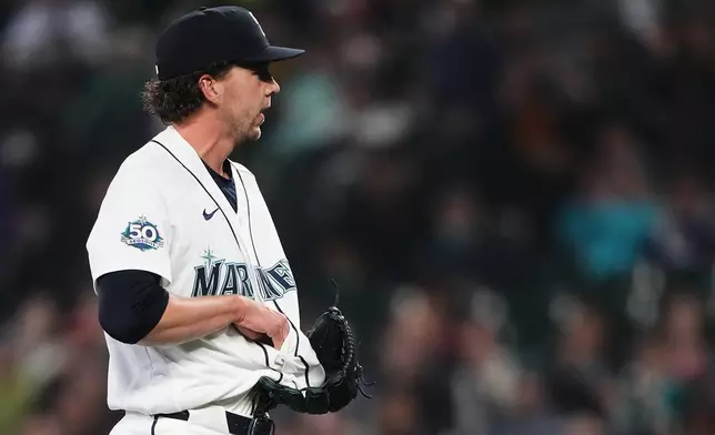 Seattle Mariners starting pitcher Logan Gilbert tries to fish out the ball after Athletics' Carlos Cortes hit a line drive base hit into his jersey during the first inning of a baseball game, Wednesday, April 22, 2026, in Seattle. (AP Photo/Lindsey Wasson)
