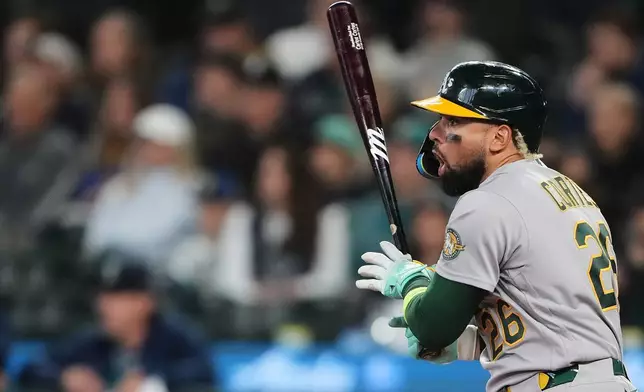 Athletics' Carlos Cortes reacts as he hits a line drive into the jersey of Seattle Mariners starting pitcher Logan Gilbert for a single during the first inning of a baseball game, Wednesday, April 22, 2026, in Seattle. (AP Photo/Lindsey Wasson)