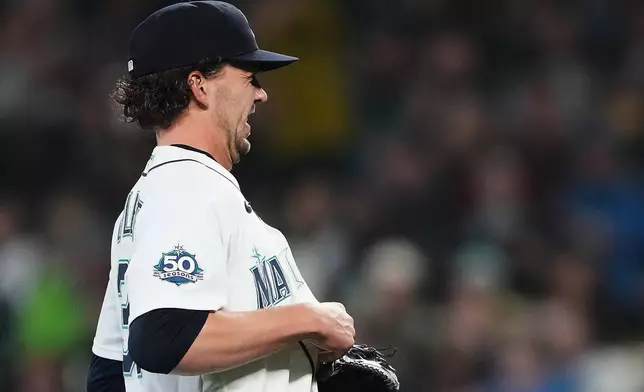 Seattle Mariners starting pitcher Logan Gilbert winces as he tries to fish out the ball after Athletics' Carlos Cortes hit a line drive base hit into his jersey during the first inning of a baseball game, Wednesday, April 22, 2026, in Seattle. (AP Photo/Lindsey Wasson)
