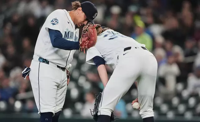 Seattle Mariners first baseman Josh Naylor checks on starting pitcher Logan Gilbert after Athletics' Carlos Cortes hit a line drive into his jersey during the first inning of a baseball game, Wednesday, April 22, 2026, in Seattle. (AP Photo/Lindsey Wasson)