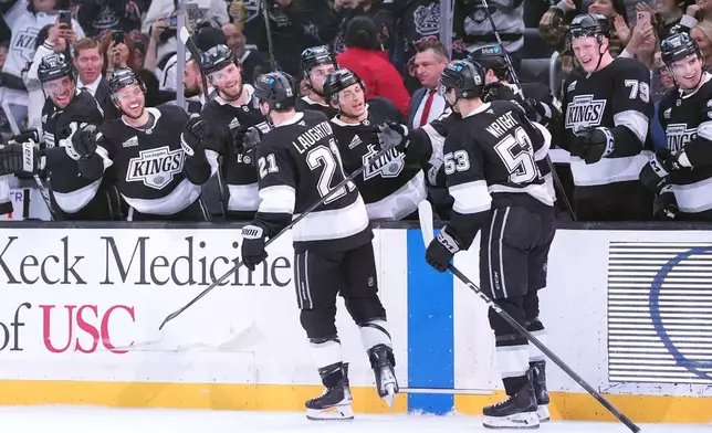 The Los Angeles Kings' bench greets center Scott Laughton (21) and right wing Jared Wright (53) after Laughton's goal against the Nashville Predators during the second period of an NHL hockey game Monday, April 6, 2026, in Los Angeles. (AP Photo/Scott Strazzante)