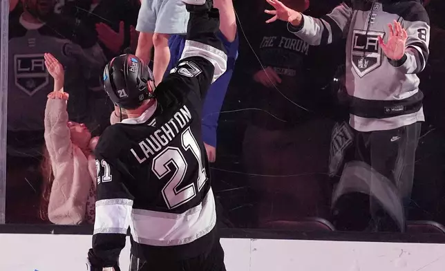 A young fan gets a hockey stick from Los Angeles Kings' center Scott Laughton (21) after Kings' shootout win over the Nashville Predators' during an NHL hockey game Monday, April 6, 2026, in Los Angeles. (AP Photo/Scott Strazzante)