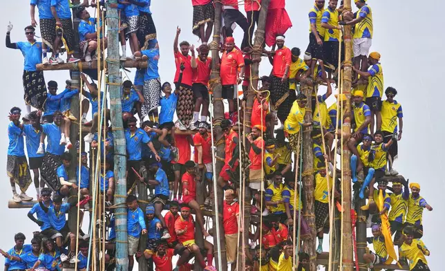 Members of the Agri-Koli community compete to erect ceremonial bamboo poles in a centuries-old annual tradition honoring the local goddess Raiba Devi, in Rave village near Mumbai, India, Friday, April 17, 2026. (AP Photo/Rafiq Maqbool)