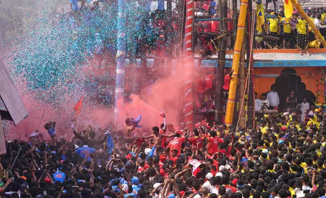 Members of the Agri-Koli community celebrate as they compete to erect ceremonial bamboo poles in a centuries-old annual tradition honoring the local goddess Raiba Devi, in Rave village near Mumbai, India, Friday, April 17, 2026. (AP Photo/Rafiq Maqbool)