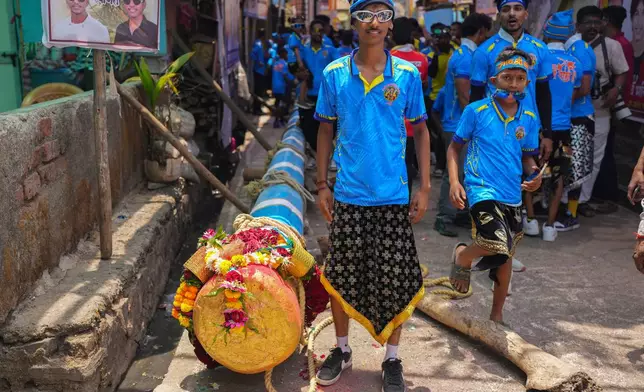A boy poses for a photograph as members of the Agri-Koli community prepare to erect ceremonial bamboo poles in a centuries-old annual tradition honoring the local goddess Raiba Devi, in Rave village near Mumbai, India, Friday, April 17, 2026.(AP Photo/Rafiq Maqbool)