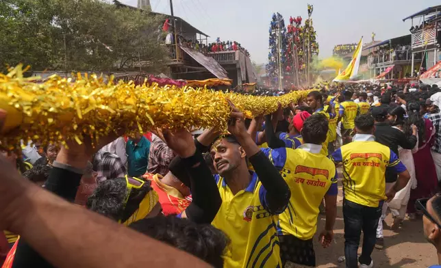 Members of the Agri-Koli community compete to erect ceremonial bamboo poles in a centuries-old annual tradition honoring the local goddess Raiba Devi, in Rave village near Mumbai, India, Friday, April 17, 2026. (AP Photo/Rafiq Maqbool)