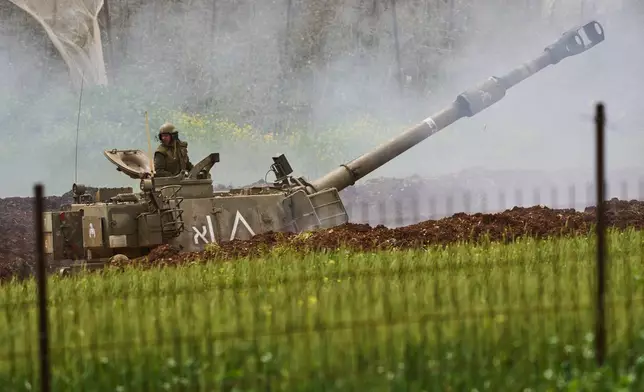 An Israeli soldier stands atop an artillery unit as it fires toward southern Lebanon from northern Israel, Wednesday, April 15, 2026. (AP Photo/Ariel Schalit)