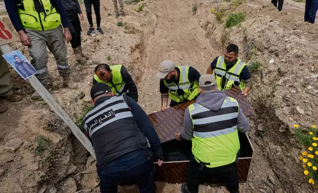 Paramedics bury the body of Ghadir Baalbaki, 19, who was killed on Tuesday in an Israeli airstrike, at a temporary mass grave in the southern port city of Tyre, Lebanon, Wednesday, April 15, 2026. (AP Photo/Hussein Malla)
