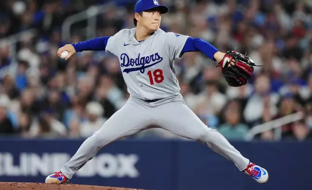 Los Angeles Dodgers pitcher Yoshinobu Yamamoto (18) works against the Toronto Blue Jays during the first inning of a baseball game in Toronto, Tuesday, April 7, 2026. (Nathan Denette/The Canadian Press via AP)