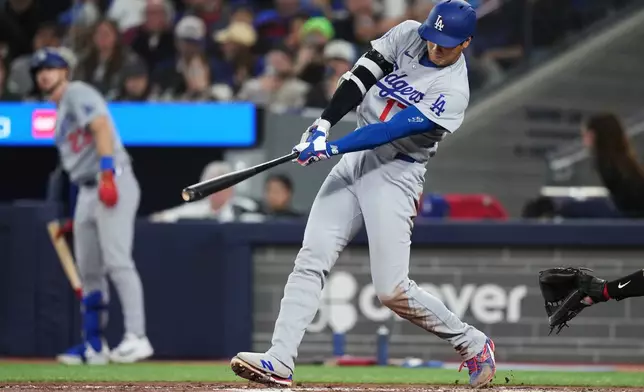 Los Angeles Dodgers' Shohei Ohtani (17) hits an RBI single against the Toronto Blue Jays during the third inning of a baseball game in Toronto, Tuesday, April 7, 2026. (Nathan Denette/The Canadian Press via AP)