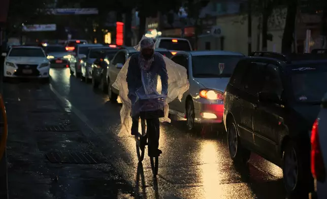 A man rides a bicycle through heavy rain in Kabul, Afghanistan, Tuesday, March 31, 2026. (AP Photo/Siddiqullah Alizai)
