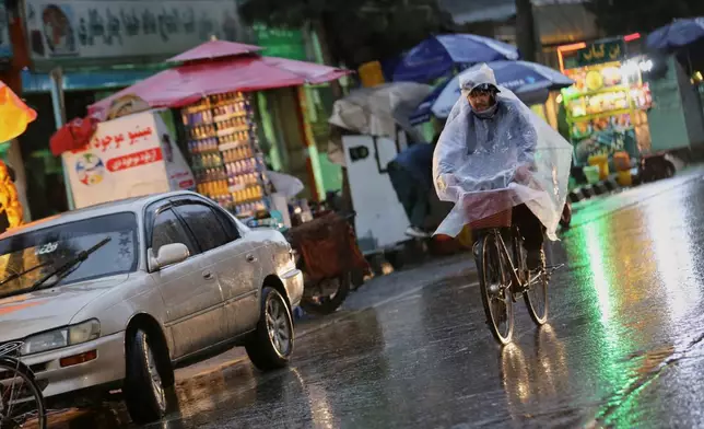 A man rides a bicycle through heavy rain in Kabul, Afghanistan, Tuesday, March 31, 2026. (AP Photo/Siddiqullah Alizai)