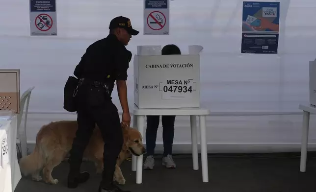 Police inspects a polling station during general elections in Lima, Peru, Sunday, April 12, 2026. (AP Photo/Guadalupe Pardo)
