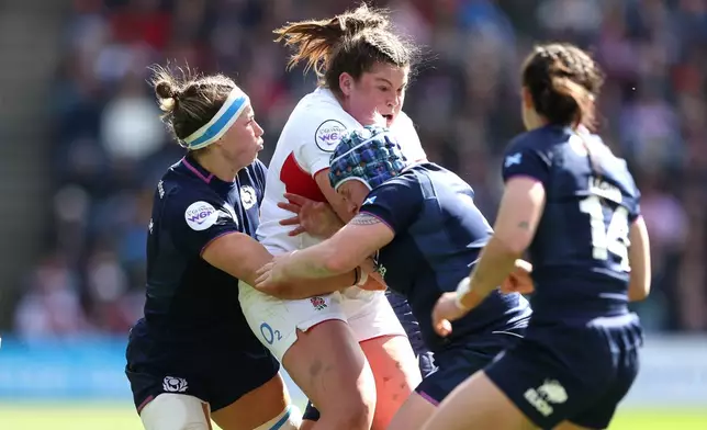 England's Maud Muir is tackled by Scotland's Rachel Malcolm, left, and Lana Skeldon during the Women's Six Nations rugby match between Scotland and England in Edinburgh, Scotland, Saturday April 18, 2026. (Ewan Bootman/PA via AP)